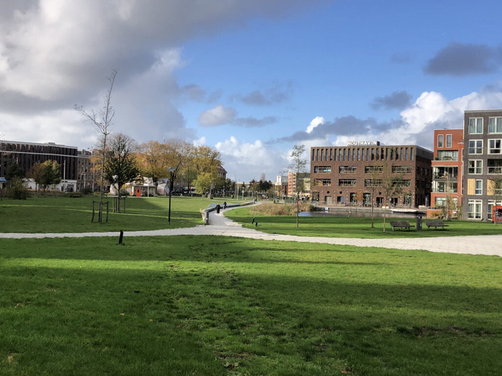 Zicht over het park op de tunnel, links de Spaarndammerbjuurt, rechts het water en de eilanden.